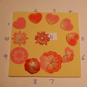 The steps to making a paper flower with punched heart shapes