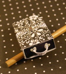 Add bling with crystals and ribbon to your altered matchbox project. Embellished matchbox